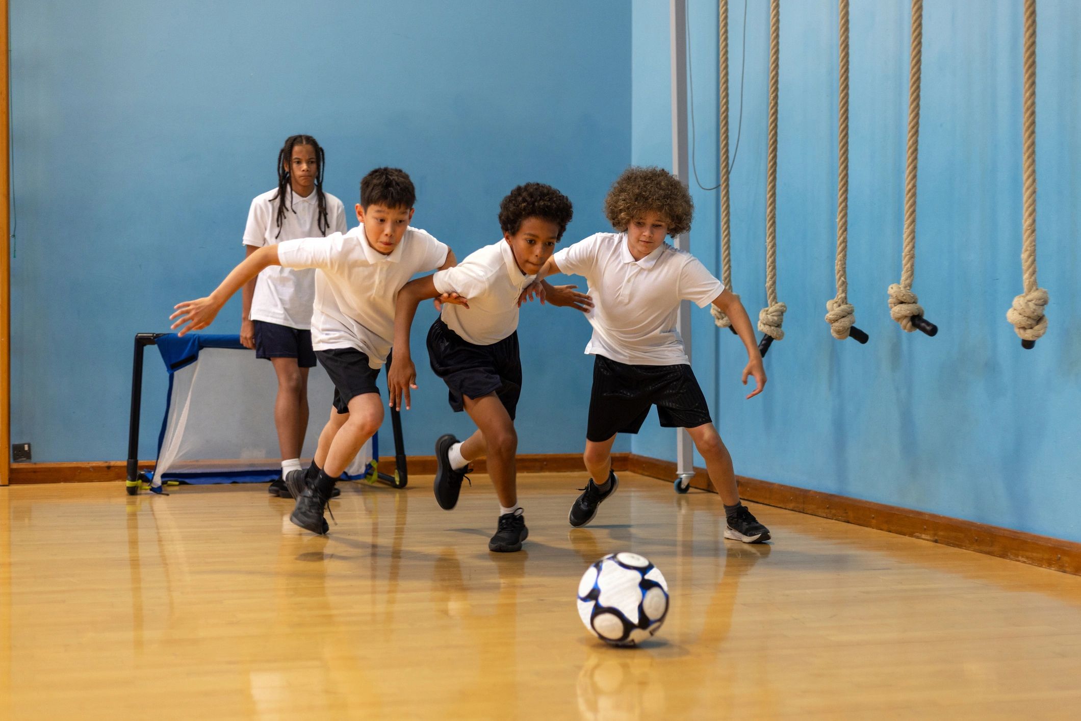 Students playing football during a PE lesson